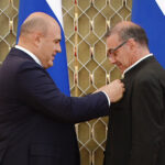 Михаил Мишустин вручает награду Александру Рудину