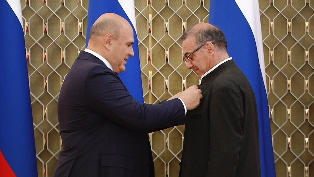 Михаил Мишустин вручает награду Александру Рудину